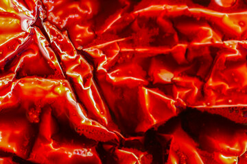 Red Metallic Texture.Silver foil folds with red liquid.Textured silver surface 