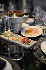 Champagne tasting, Wine glasses are on the table, stylish table setting, wine is poured from a bottle and decanter, sparkling wine bubbles, snacks, people smell the aroma and taste the wine