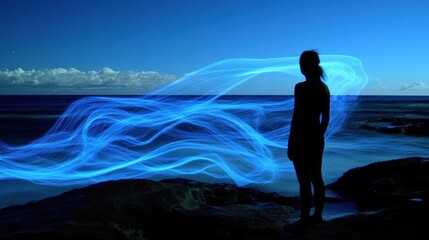 Fototapeta premium Woman ocean light painting serenity night