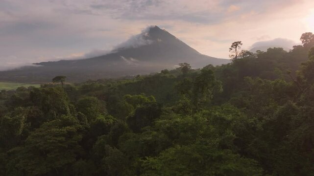 Enjoy breathtaking aerial views of Arenal Volcano and Laguna de Arenal at sunrise, surrounded by mist and vibrant green forests that showcase the areas natural beauty and picturesque scenery