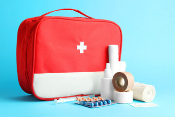 First aid kit. Different medical supplies on light blue background