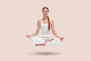 Young woman levitating during meditation on beige background. Practicing yoga