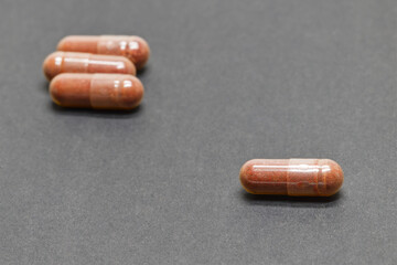 Brown Capsules with antioxidants, astaxanthin, on Dark Background
