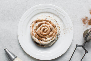 Overhead view of frosting coated cinnamon cookies, top view of cinnamon cookies with a vanilla cream frosting, process of making bakery style cookies