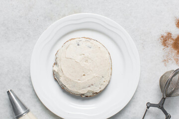 Overhead view of vanilla frosting coated cookies, top view of vanilla cookies with a vanilla cream frosting, process of making bakery style cookies