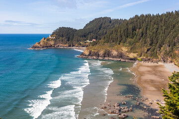 Fototapeta premium Ocean coast in low tide. Heceta Lighthouse on the background