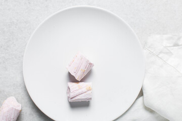 Overhead view of Nigerian Balewa candy, top view of hausa alewa candy on a white background, pulled hard sugar candy on a white countertop
