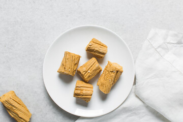Overhead view of Nigerian Balewa candy, top view of hausa alewa candy on a white background, pulled hard sugar candy on a white countertop