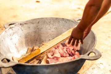 Close-up shot. Process of making pork rinds in a metal pot.