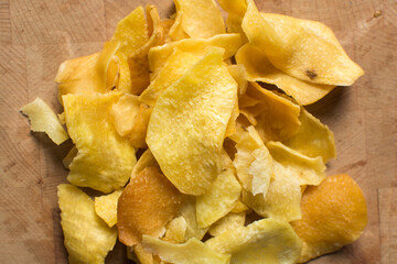 Overhead view of golden sweet potato chips on wood countertop, top view of crispy fried sweet...