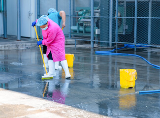 Two female staff cleaning the floor.