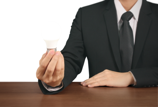 Innovative business leader holding energy-efficient light bulb office environment professional action shot focus on sustainability