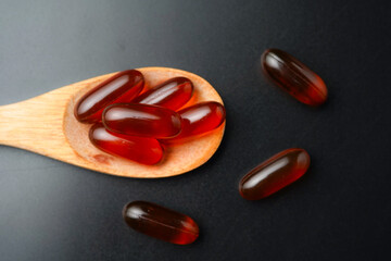 Vitamin capsules in a wooden spoon, soft gels, Fish oil capsules, omega 3, omega 9, vitamin D,...