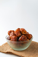 Dates fruit sukari or kurma sukari, in bowl isolated on white background