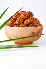 Dates fruit sukari or kurma sukari, in wooden bowl isolated on white background