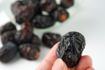 Dates fruit ajwa or kurma ajwa, in hand isolated on white background