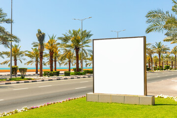 mockup billboard on empty road  with blue sky and palm trees in a sunny day