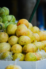 Ripe yellow guava fruit piled up in front of a fresh fruit shop in a traditional market, sweet, cheap and healthy yellow guava fruit, organic fresh fruit farmer