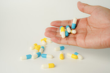 Male hand holding white capsule pill, isolate background, pharmacy, medicine, health care