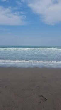 Blue Skies and Rolling Waves on a Tropical Black Sand Beach
