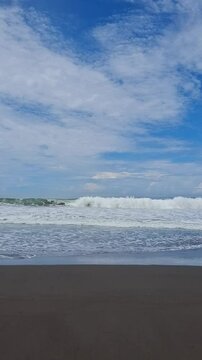 The beauty of the crashing waves on the beach under a clear sky
