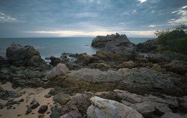 A sandy beach full of rocks on a quiet morning