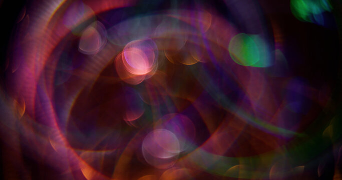 Defocused reflection. Festive beam. Color sparkling shining particles lens flare motion on blurred bokeh light background.