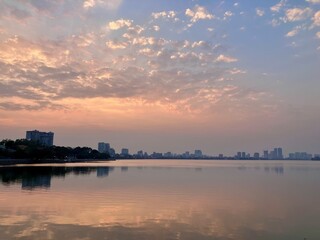 Pastel Urban Horizon: Soft Cloudscape Reflecting on Calm Waters on West Lake in Hanoi, Vietnam