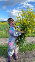Little girl with a bouquet of wild flowers in nature