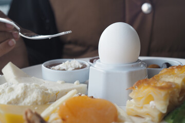 Breakfast with soft-boiled egg and assorted cheeses served at a cafe
