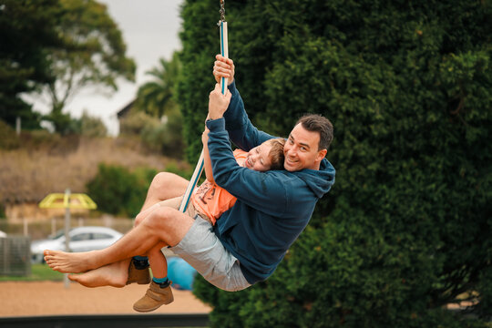 Father and son riding flying fox together at the park