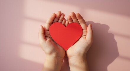 Obraz premium Hands Holding Red Heart against Soft Pink Background 