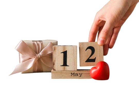 Hand places a wooden block calendar showing May 12, isolated on white, PNG