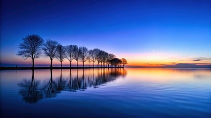 Fototapeta premium Serene Sunset Reflection A Line of Silhouetted Trees Mirrored in Tranquil Waters at Dusk