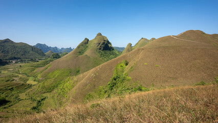 Fototapeta premium Set amidst majestic, undulating hills, Ba Quang Hill is of unique, wild and poetic beauty. Located about 70km east of Cao Bang city center, Ba Quang grass hill (also known as Vinh Quy grass hill) .