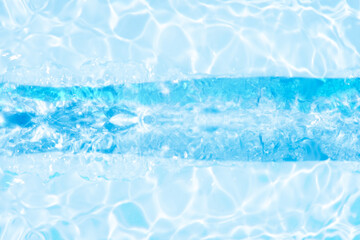 Obraz premium Blue water with ripples on the surface. Defocus blurred transparent blue colored clear calm water surface texture with splashes and bubbles. Water waves with shining pattern texture background.