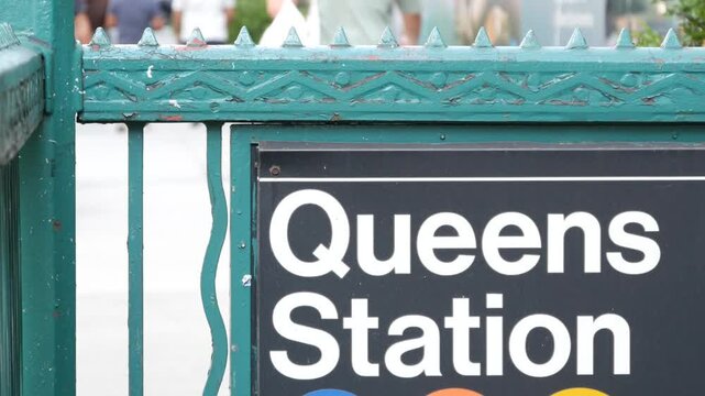 New York subway sign, Queens underground metro station. Metropolitan entrance fence, public transport exit. Long Island city street, NYC United States. Navigation text on signboard. Pedestrians people