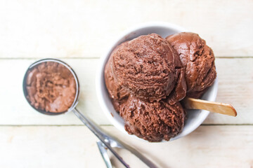 chocolate scoop ice cream in a bowl on a wooden table