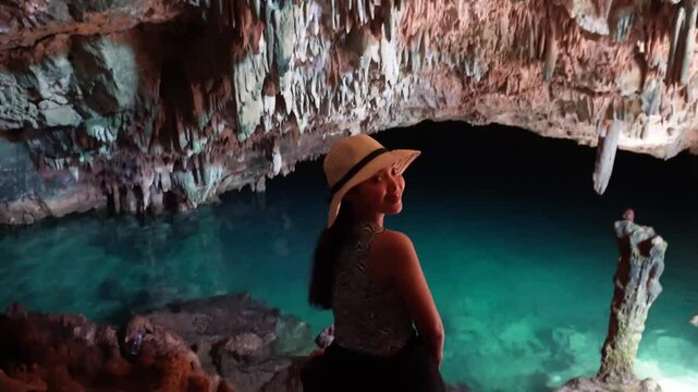 Happy young Asian woman enjoying holiday and scenery at Rangko Cave, Labuan Bajo, Indonesia.