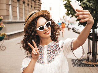 Beautiful smiling model with afro curls hairstyle dressed in summer hipster white dress. Sexy...
