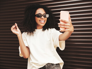 Beautiful woman with afro curls hairstyle.Smiling hipster model in white t-shirt. Sexy carefree...