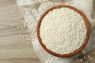 Raw white rice in bowl on wooden background
