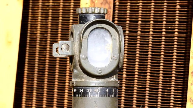Small Green Periscope Rotates Against A Grated Yellow Background