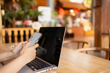 digital nomad is working in cafe while using laptop and smartphone to stay connected and productive...
