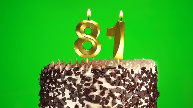 Burning candles number 81 on birthday cake against chroma key background. Eighty-first birthday. Birthday celebration