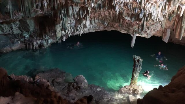Traveler visiting Rangko Cave and swimming in the water inside the cave, Labuan Bajo, Indonesia tourist destination.