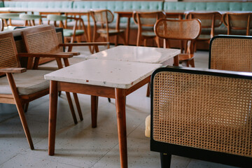 Stylish vintage cafe interior with rattan chairs and marble tables