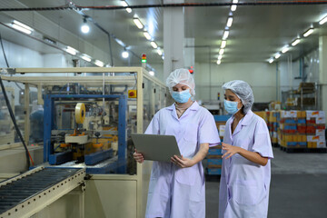 Food factory staff reviewing production data in a food packaging facility