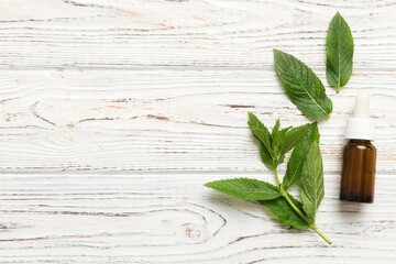 Natural Mint Essential Oil in a Glass Bottle. organic cosmetics with herbal extracts of mint on...