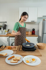 Asian young woman cooking healthy food in kitchen in the morning at home. 